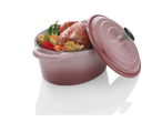 Frango assado e legumes em uma panela de ferro fundido rosa.
