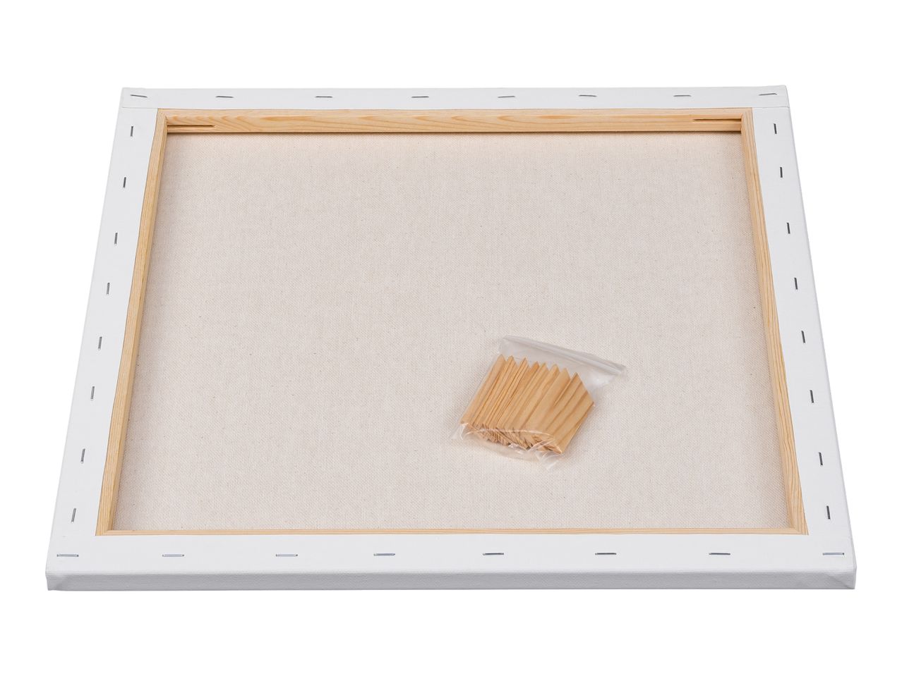 Back of a blank white stretched canvas with wooden frame and a bag of wooden wedges.