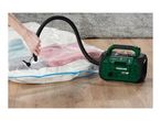 Person using a vacuum pump to seal a storage bag filled with towels.