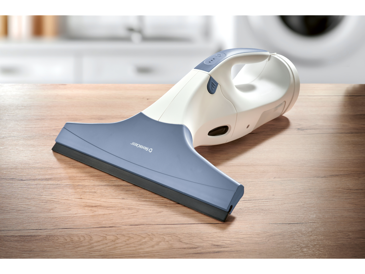 Silvercrest® Akku-Fenstersauger na drvenom stolu u kuhinji.