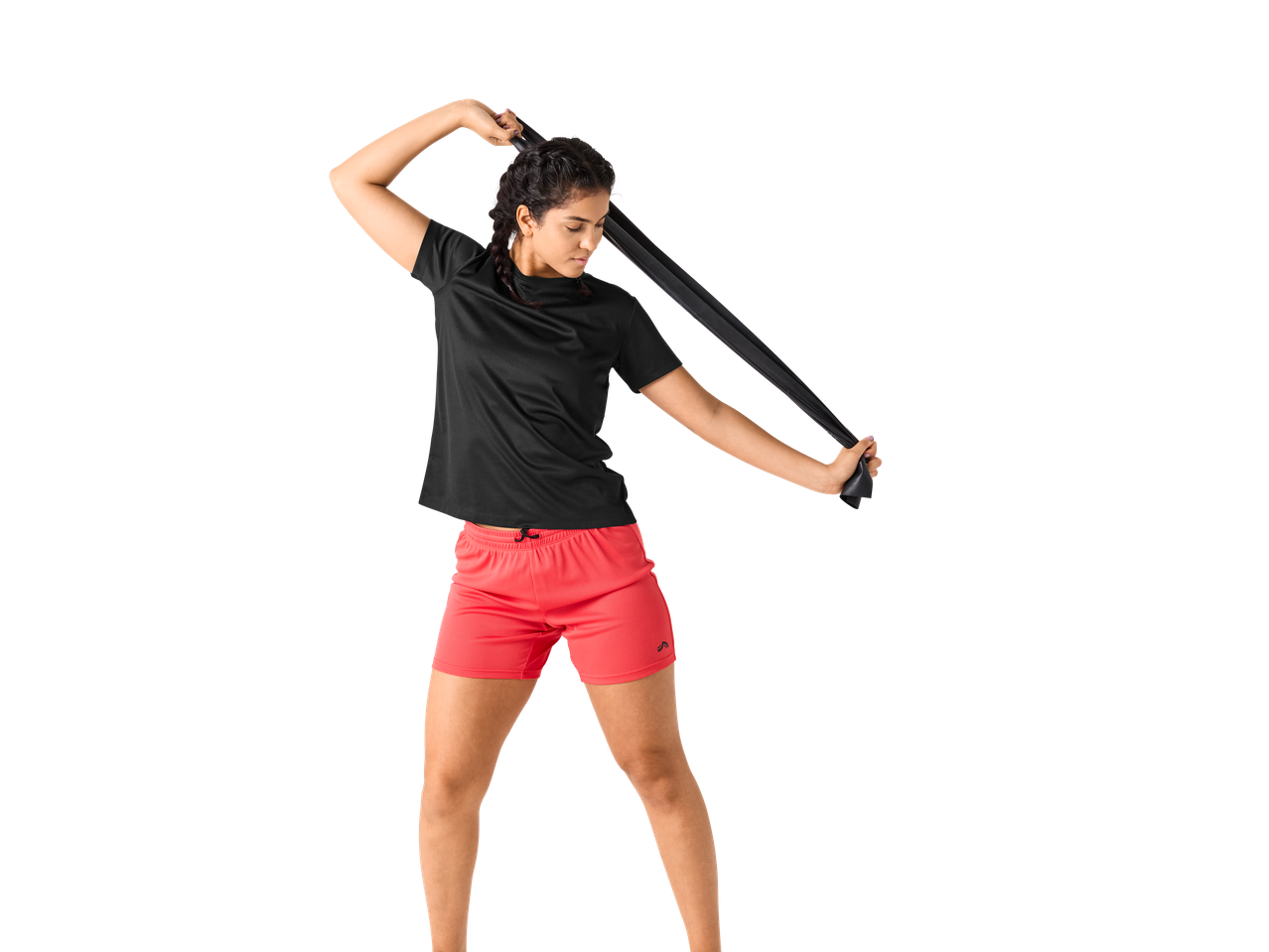 Mulher de t-shirt preta e calções vermelhos a alongar-se com uma banda de resistência.