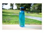 A blue reusable water bottle standing on a wooden table in a park.