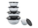 Stack of clear glass mixing bowls with black lids, one bowl with lid detached.