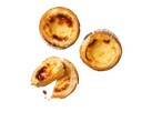 Trois tartes aux œufs portugaises, dont une est cassée en deux.
