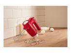 Red hand mixer with beaters and dough hooks on a wooden countertop