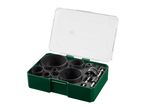 Hole saw set with various sizes of saw blades and drill bits in a green and clear case.