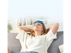 Woman relaxing on a couch with an ice pack on her forehead.