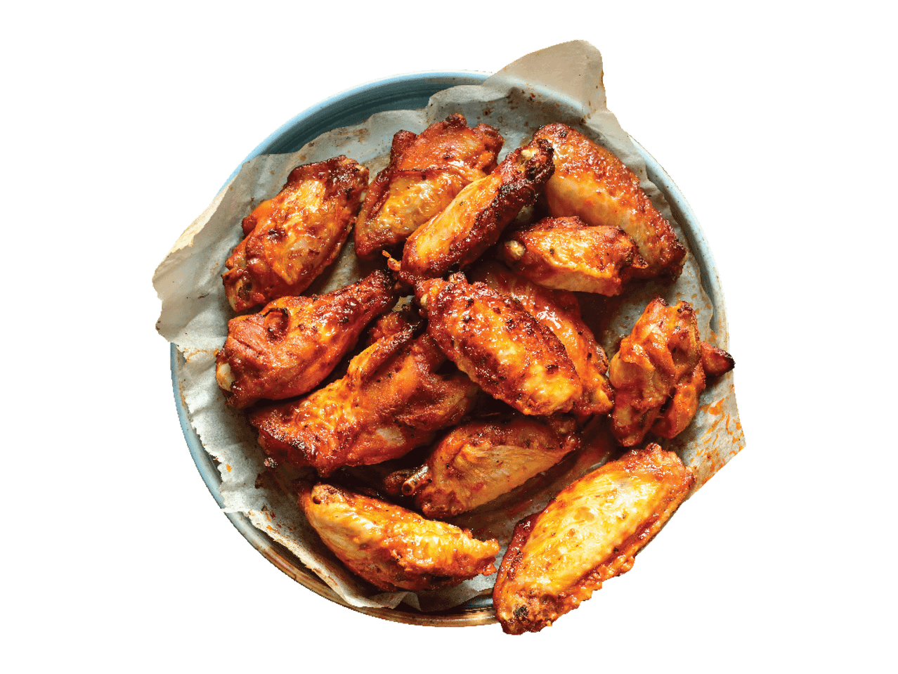 Taldrikul, mis on vooderdatud küpsetuspaberiga, on BBQ-kastmes kanatiivad.