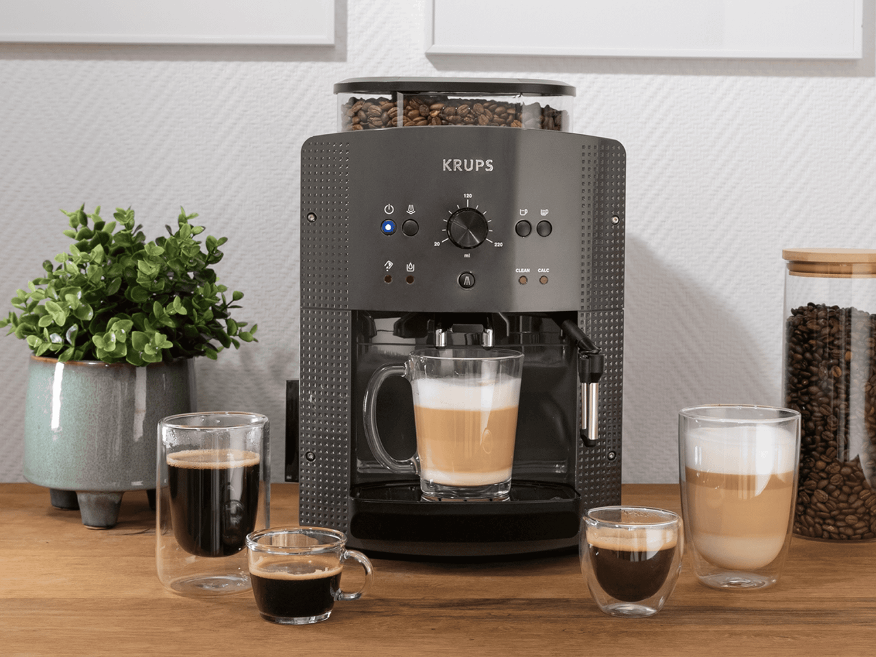 KRUPS Kaffeevollautomat mit Kaffeebohnen und verschiedenen Kaffeespezialitäten