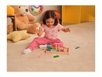 A young girl playing with colorful wooden blocks on a rug, surrounded by toys.