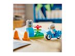 Toy motorcycle with rider, traffic cones, and a traffic light on a wooden surface.
