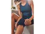Woman applying a knee support on a couch.
