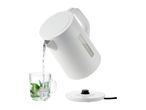 A white cordless electric kettle pours water into a glass.