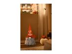 Halloween gnome with a glowing orange hat next to decorative pumpkins