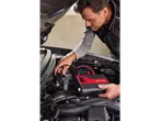 Um homem usa um arrancador portátil ULTIMATE SPEED para ligar um carro.