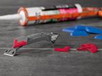 Silicone sealant tube and plastic tile spacers for tiling projects.