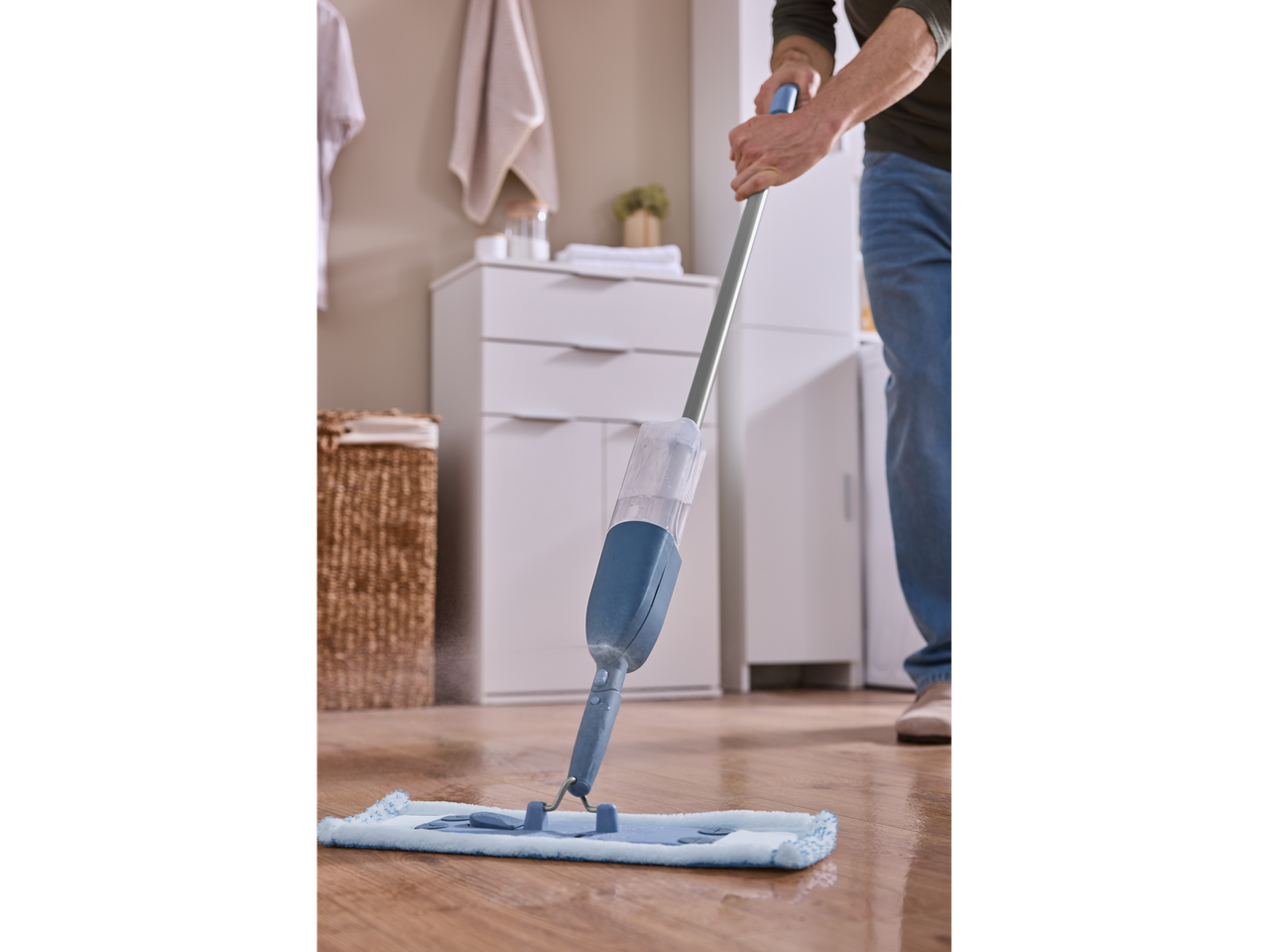 Osoba čisti drveni pod sprej mopom.