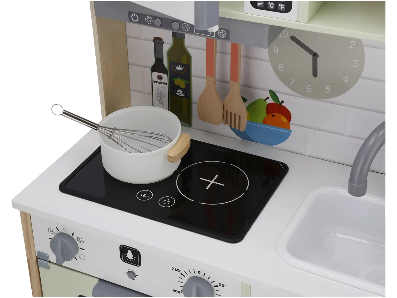 Cucina giocattolo in legno con pentola bianca, frusta e bottiglie di olio e vino.