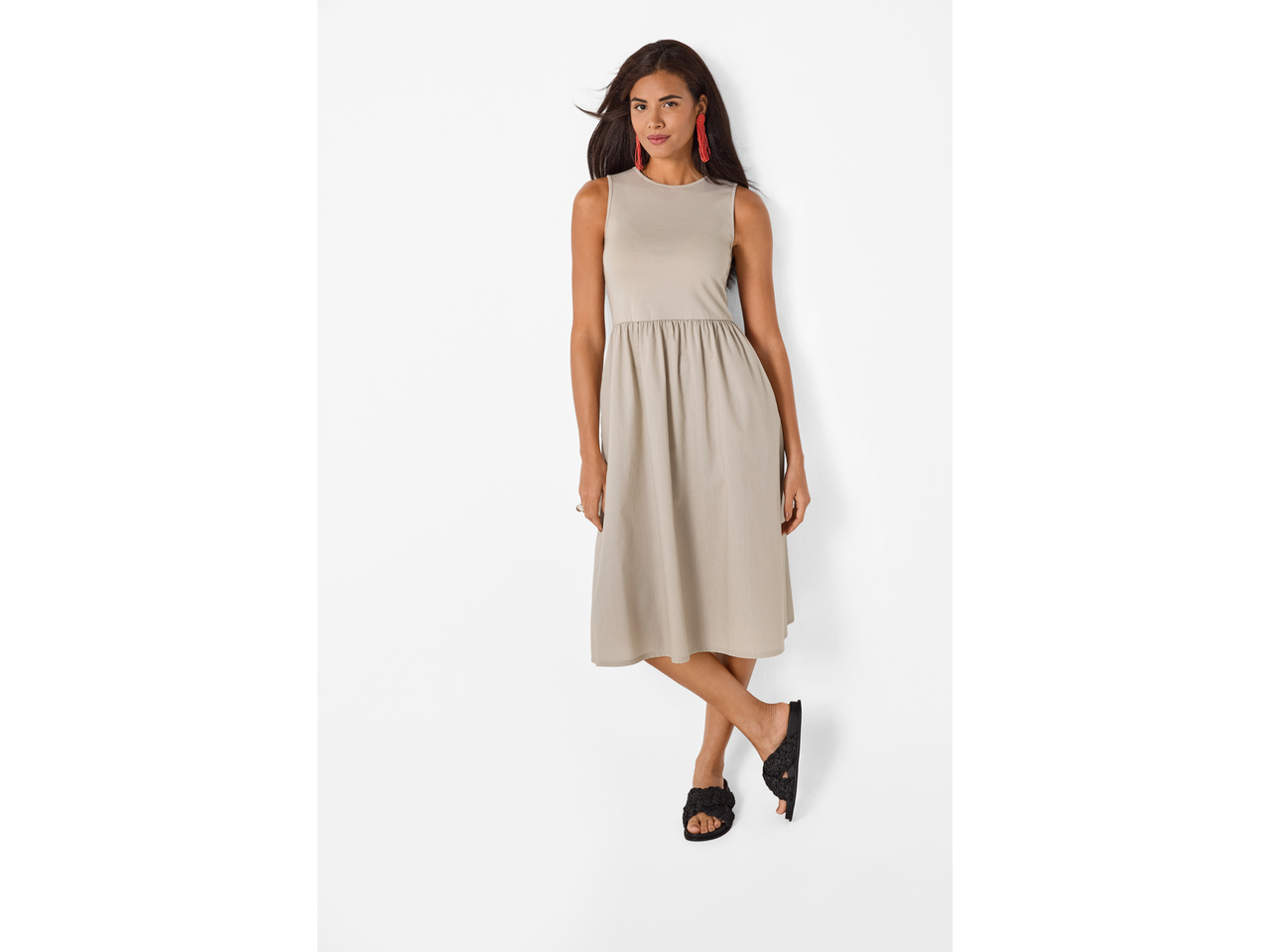 Mulher com vestido comprido Esmara bege e sandálias pretas.