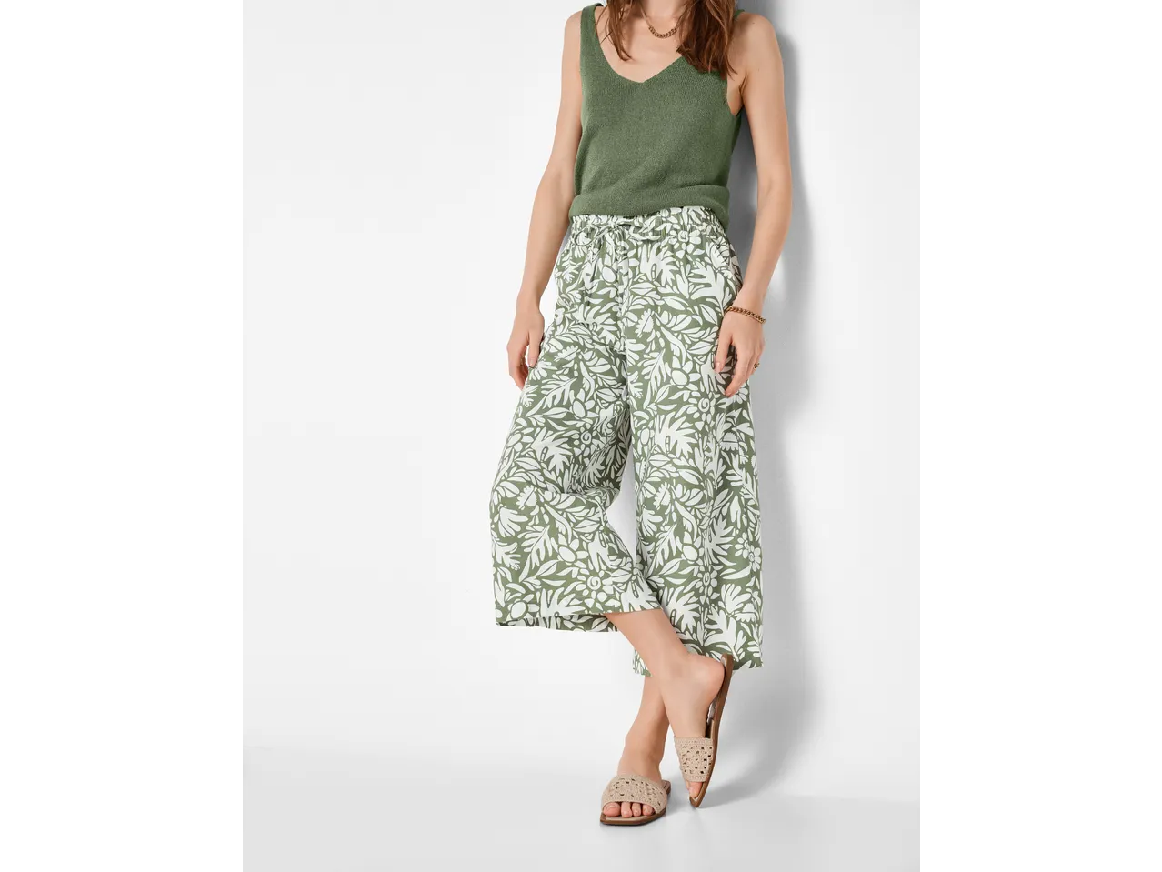 Pantaloni culotte ESMARA de damă, model floral verde și alb, cu un maiou verde.