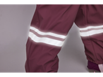 Detaliu al unor pantaloni impermeabili bordo cu dungi reflectorizante.