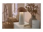 Mushroom-shaped table lamp on a white cabinet with a vase and candle in a cozy room.