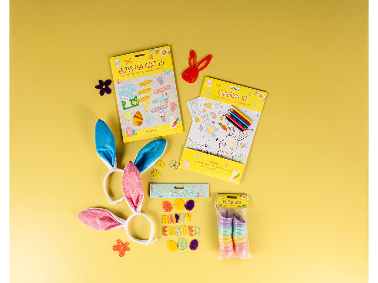 Easter egg hunt kit, colouring set, bunny ears, gel window stickers, and fillable eggs on yellow.