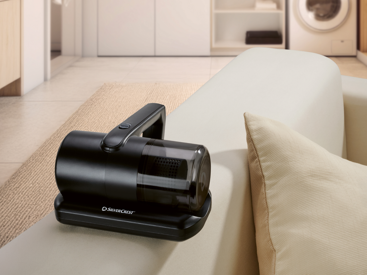 Черна ръчна прахосмукачка на диван в светла всекидневна