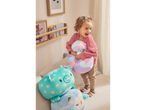 A happy child holding a Lupilu Squishy Plush Toy, with other plush toys nearby.