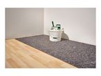A room with a paint bucket, roller, and floor protection fleece on a wooden floor.