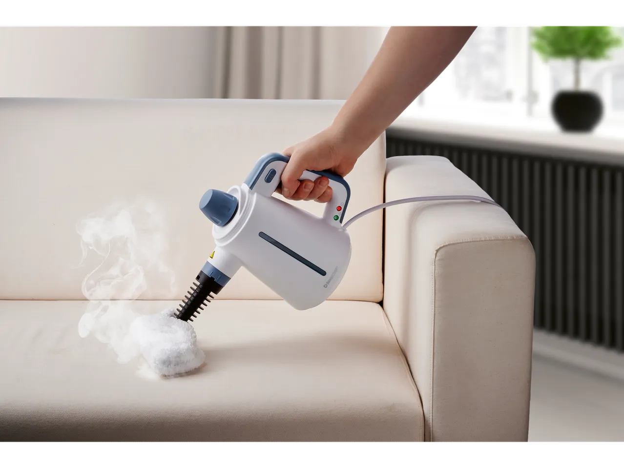 Ръчна парочистачка Silvercrest® почиства светъл диван с пара.