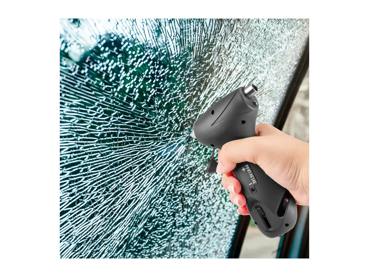 A hand using an emergency escape tool to shatter a car window.