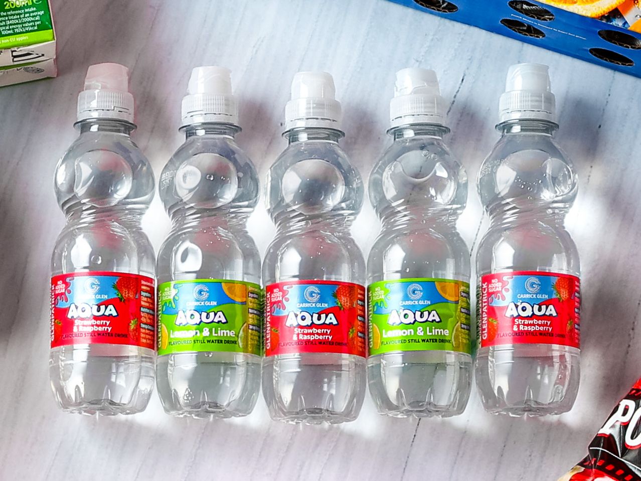 Five Carrick Glen Aqua flavored still water bottles, two strawberry & raspberry and three lemon & lime.