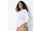 Mulher com blusa branca bordada ESMARA e calças bege
