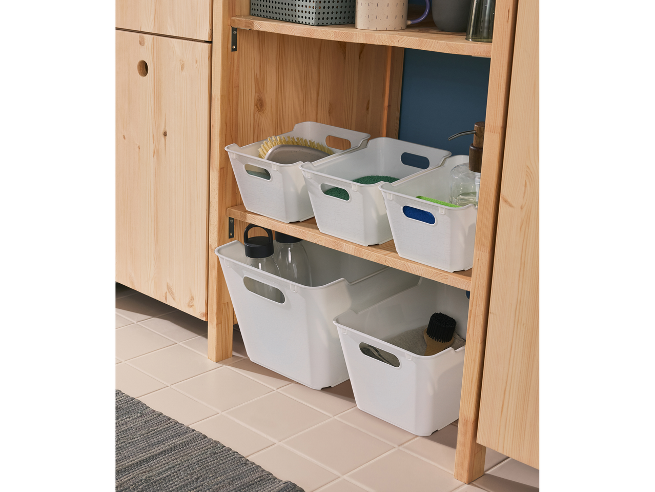 White plastic storage bins neatly organized on a light wood shelf unit.
