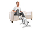 Homem sorridente a usar uma mini bicicleta ergométrica Crivit sentado num sofá.