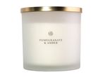 Frosted glass jar candle with a gold lid, labeled Pomegranate & Amber.