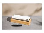 A dual-sided sharpening stone in a bamboo base, with a sharpening guide next to it.
