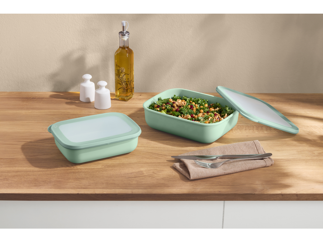 SILVERCREST® Food Container Set with salad, oil, and salt and pepper shakers on a wooden table.