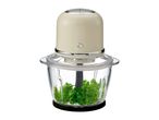 Electric food chopper with a glass bowl containing fresh parsley