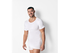 A man smiles while wearing a white undershirt and Calvin Klein underwear.