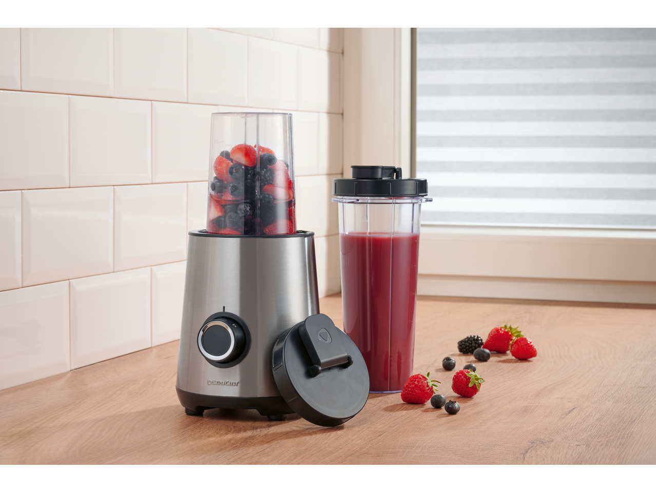 SILVERCREST® 300W Smoothie Maker with berries, a smoothie, and a lid on a wooden counter.