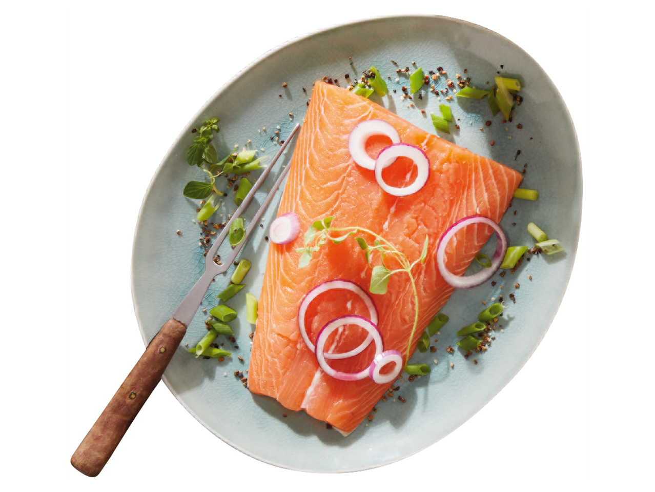 Парче сьомга с червен лук, зелен лук и подправки върху синя чиния с вилица.