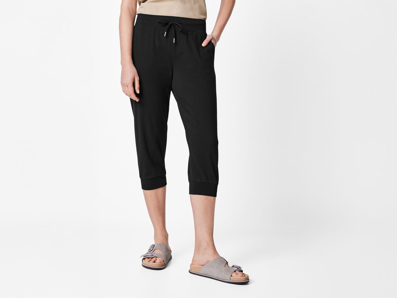 Női fekete capri nadrág és szürke Birkenstock szandálok.