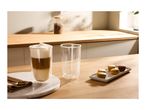 A tall glass of latte macchiato, an empty glass, and a plate of colorful macarons on a wooden table.
