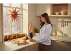 Mulher a usar o picador multifunções SILVERCREST para vegetais numa cozinha de Natal.