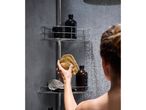 Woman in shower holding a natural sponge, with shower caddy and bottles.
