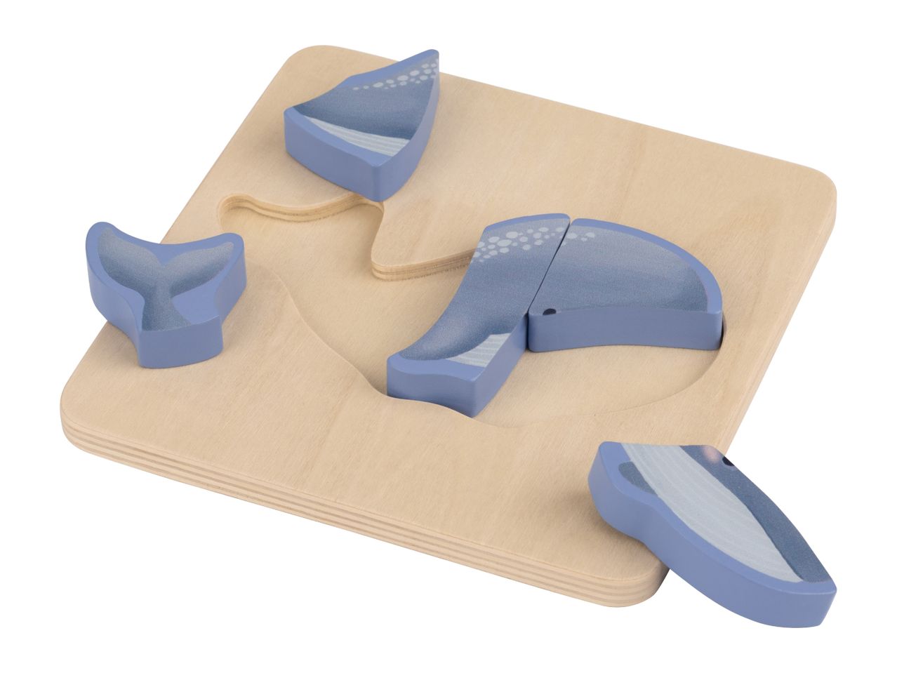 Wooden whale puzzle with blue pieces, some showing water splashes, on a light wood board.