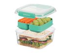 Three-tier lunch box with a sandwich, carrot sticks, and green grapes.