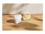 Water filter cartridge next to a glass of water with lemon and mint on a wooden surface.